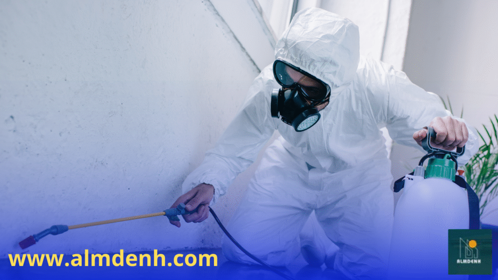 فريق عمل يرتدي الزي الواقي أثناء تقديم خدمة من شركة مكافحة البق في عجمان داخل منزل سكني.