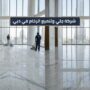 فريق عمل متخصص من شركة جلي وتلميع الرخام في دبي يقوم بتلميع أرضية واسعة في طابق مرتفع ببرج يطل على برج خليفة باستخدام ماكينات الكريستال الحديثة.