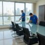 فريق عمل شركة تنظيف مكاتب في الشارقة يقوم بمهام جلي الأرضيات، مسح الغبار، وتنظيف النوافذ في مكتب يطل على بحيرة خالد ومسجد النور.