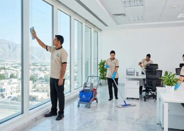 فريق عمل من شركة تنظيف مكاتب في راس الخيمة يقوم بتنظيف الواجهات الزجاجية والمكاتب الداخلية المطلة على جبال رأس الخيمة.