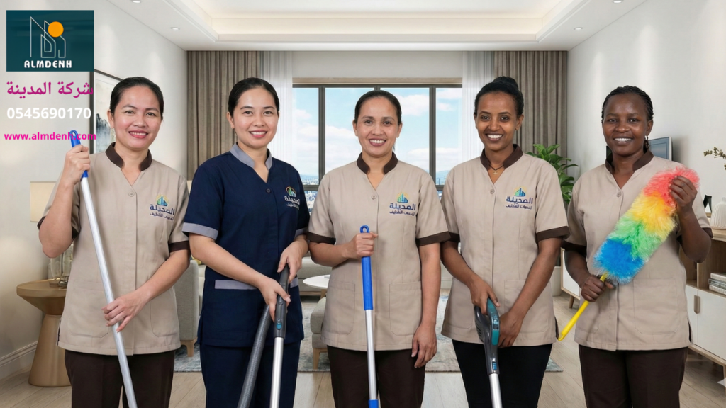 فريق عمل متنوع الجنسيات يضم خادمات نظافة بالساعة في عجمان يرتدين زياً موحداً ويحملن أدوات التنظيف داخل منزل نظيف.