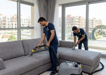 فريق شركة المدينة يقوم بتنظيف كنب بالبخار في شقة سكنية تطل على معالم المنطقة، بصفتها أفضل شركة تنظيف كنب في أرجان دبي.