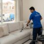 عامل محترف من أفضل شركة تنظيف كنب في الجزات يقوم بالغسيل العميق للأرائك وإزالة البقع باستخدام أحدث أجهزة الشفط والتنظيف.