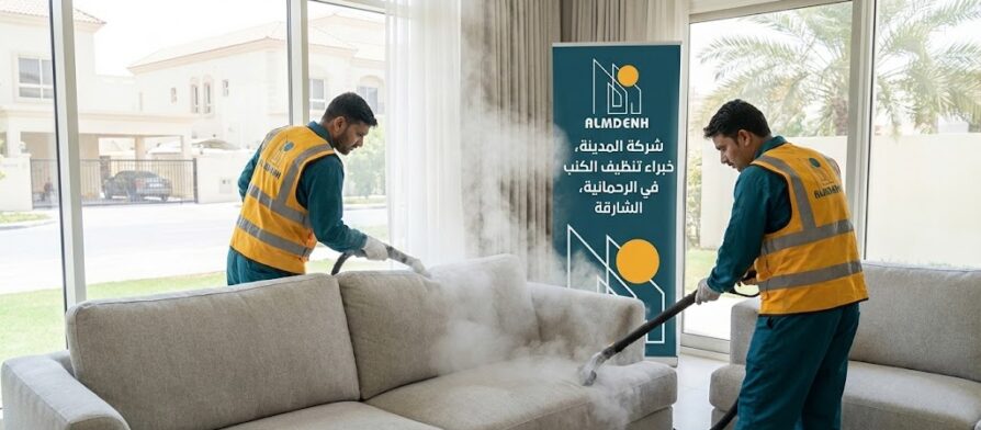 عمال شركة المدينة، بصفتها شركة تنظيف كنب في الرحمانية بالشارقة، يقومون بتنظيف كنب فاتح اللون بالبخار داخل فيلا، مع ظهور لافتة تحمل الهوية البصرية للشركة.