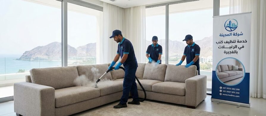 فريق عمل شركة المدينة، بصفتها شركة تنظيف كنب في الرغيلات، يستخدم تقنية البخار لغسيل كنب في غرفة مطلة على البحر، مع لافتة إعلانية للخدمة.