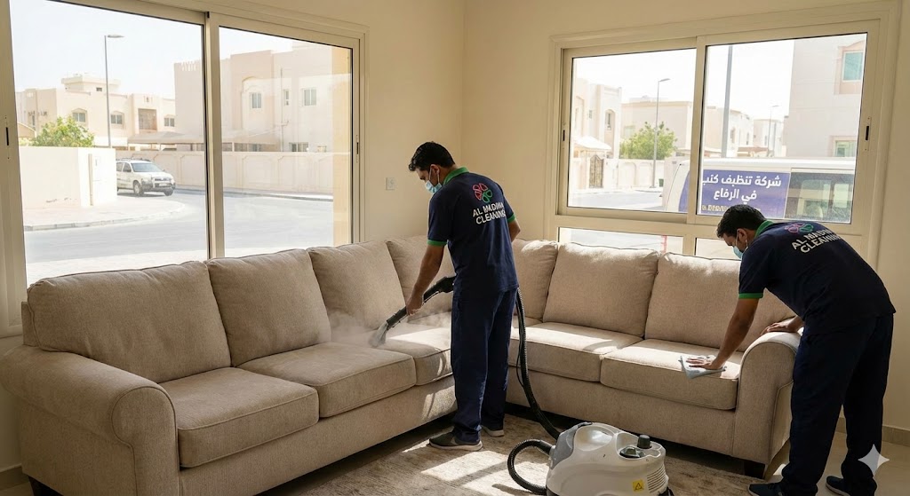 عمال شركة المدينة أثناء غسيل وتعقيم الأثاث الفاتح باستخدام أجهزة البخار، كأفضل شركة تنظيف كنب في الرفاع.