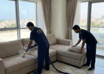 فريق عمل شركة المدينة أثناء تنظيف وغسيل الكنب بالبخار، كأفضل شركة تنظيف كنب في الممر.