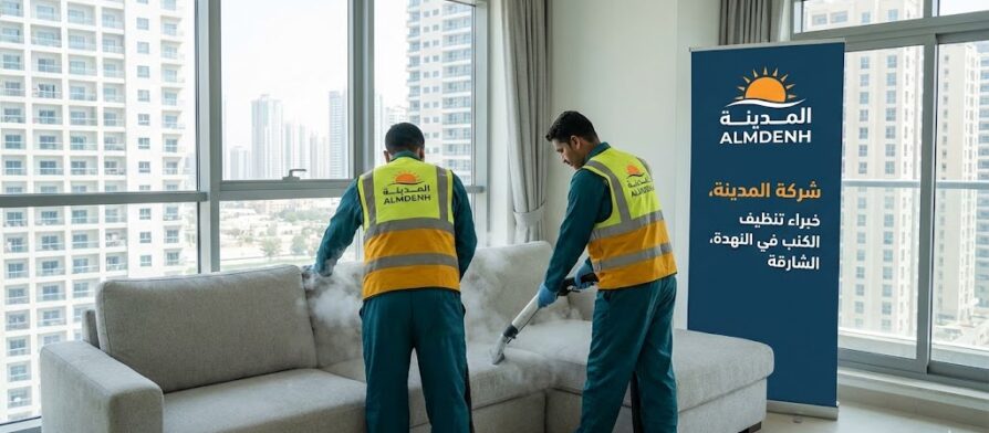 عمال شركة المدينة، بصفتها شركة تنظيف كنب في النهدة بالشارقة، يغسلون كنباً فاتح اللون بالبخار في شقة ذات إطلالة على أبراج المدينة، مع ظهور لافتة الشركة.