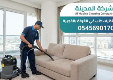 فني محترف يستخدم جهاز الغسيل والشفط العميق لتنظيف أريكة قماشية حديثة، يمثل خدمات أفضل شركة تنظيف كنب في الغرفة بإمارة الفجيرة.