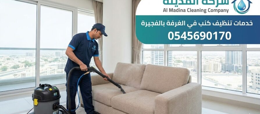 فني محترف يستخدم جهاز الغسيل والشفط العميق لتنظيف أريكة قماشية حديثة، يمثل خدمات أفضل شركة تنظيف كنب في الغرفة بإمارة الفجيرة.
