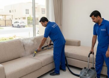 فريق عمل شركة المدينة بزي موحد يقوم بتنظيف كنب بالبخار داخل منزل سكني، مما يبرز خدمات أفضل شركة تنظيف كنب في الحليو لإزالة البقع والتعقيم.