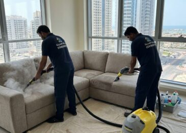 فريق عمل شركة المدينة يقوم بخدمات شركة تنظيف كنب في الراشدية داخل شقة في طابق مرتفع، مستخدمين أجهزة البخار لإزالة البقع والغبار المتراكم.