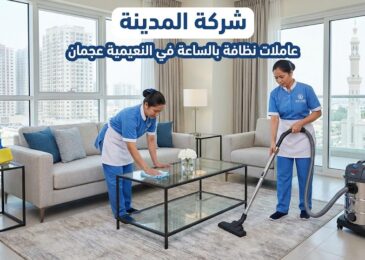 صورة توضح فريق عاملات نظافة بالساعة في النعيمية عجمان من شركة المدينة وهن يقمن بتنظيف وترتيب غرفة معيشة داخل شقة سكنية تطل على أبراج المدينة