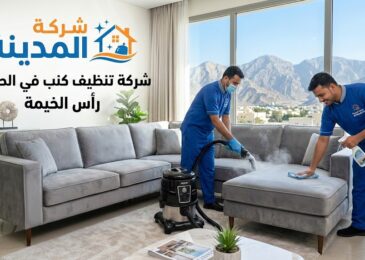 فنيو شركة المدينة يستخدمون أجهزة التنظيف بالبخار على كنب في صالة معيشة عصرية في الحرامل، رأس الخيمة، مع مناظر جبلية في الخلفية.