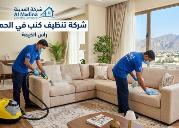 فنيو شركة المدينة بزيّهم الأزرق يستخدمون ماكينة التنظيف بالبخار والشفط القوي لغسيل كنب في صالة معيشة فخمة بمنطقة الحمرانية، رأس الخيمة.