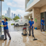 فريق عمل شركة المدينة يقوم بخدمات تنظيف منازل في ابوظبي بعد الامطار، حيث ينظفون الواجهات الزجاجية ويجففون مياه الفناء الخارجي باستخدام معدات حديثة.
